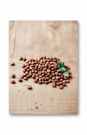 Roasted Coffee Beans with Fresh Leaves on Wooden Surface