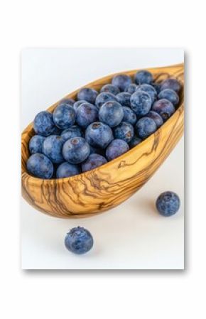 A beautifully crafted wooden bowl filled with fresh blueberries, showcasing their vibrant color and texture