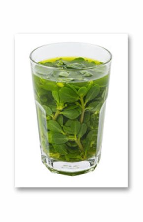 Green leaves and stems fill a glass, creating a refreshing natural beverage on white