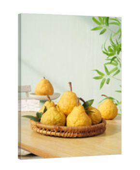 Fresh Yellow Pears in Wicker Basket on Wooden Table with Green Plants in Natural Light