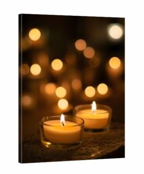 Two candles glow softly in the dark creating a warm and inviting atmosphere for relaxation and reflection