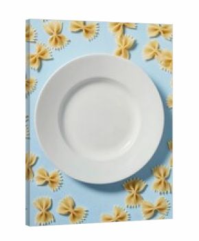 Empty white plate surrounded by farfalle pasta against a pastel blue background