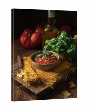 A Rustic Still Life Featuring Dried Pasta, Fresh Basil, and Homemade Tomato Sauce Ready for a Delicious Meal 