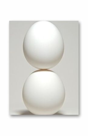 Two white eggs balanced delicately on top of each other
