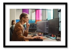 Female Software Engineer Writing Code on Desktop Computer with Multiple Screens Setup in Coworking Office Space. Professional Caucasian Woman Working on SaaS Platform For Innovative Startup.