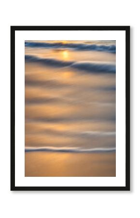 Smoothly blurred sky over a sun-kissed calm sea, golden sands of a tranquil beach in the foreground