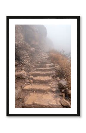 Stone Steps Leading Upward Through Foggy Mountain Cliffside
