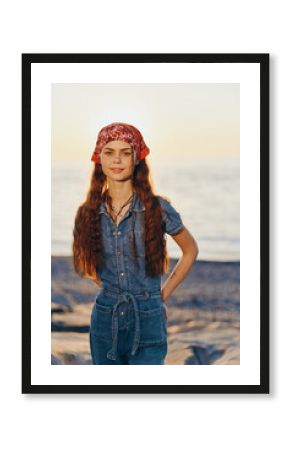 Lifestyle woman in modern boho-western denim street style with a red bandana and long hair at sunset beach, film color tones creating warm, natural mood and authentic vibe.