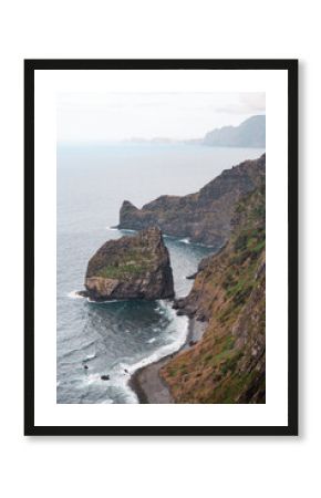 Aerial view of Madeira’s rugged green cliffs dropping sharply into the sea with rocks emerging from the water