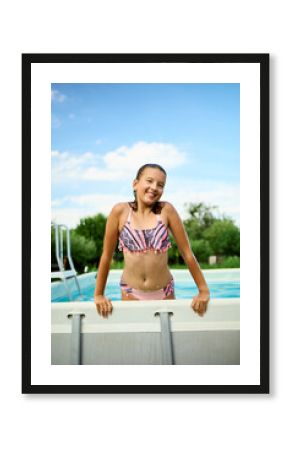 Teen girl enjoying a summer day by the pool with a cheerful smile and relaxed demeanor in a sunny outdoor setting
