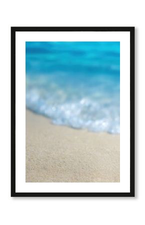Close up of soft wave washing sandy beach with turquoise water in background, creating relaxing and idyllic summer vacation scene