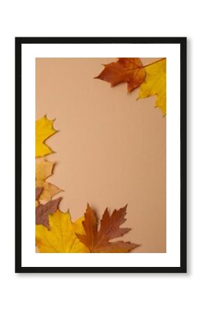 A vertical arrangement of autumn leaves on a brown background 