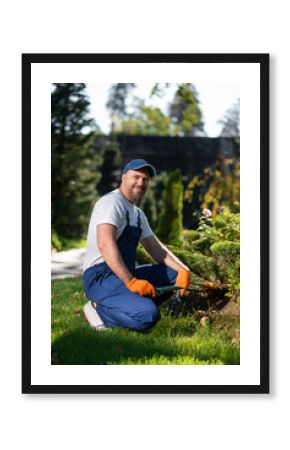 Man in uniform working with gardening tools during outdoor maintenance