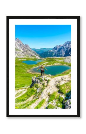 Hiker admiring the tre cime di lavaredo and the dolomites lakes in summer