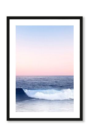 Soft Pink Sunset Over a Calm Ocean with a Gently Rolling Wave