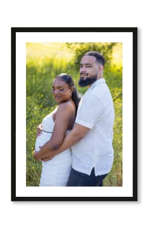On a beautiful, sunny summer day, a loving African American couple enjoys an intimate and affectionate moment outdoors, joyfully celebrating their exciting pregnancy in a stunning natural setting