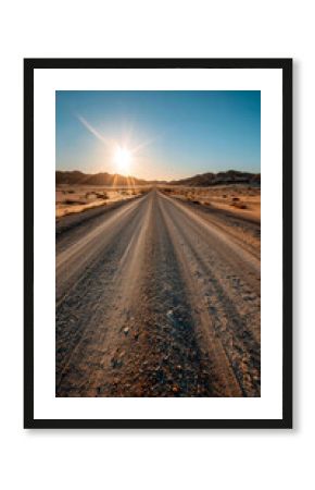 Desert Road at Sunset: A sun-kissed dirt road stretches into the horizon, framed by dunes under a clear blue sky.