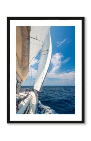 Side of a sailing yacht cutting through the sea with full sails near Croatia. Motion, freedom, sailing lifestyle and adventure on the open water.