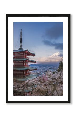 Stunning view of Mount Fuji from Chureito Pagoda in Japan during cherry blossom season.  The iconic red pagoda and pink blossoms create a picturesque scene against the majestic backdrop of Fuji.