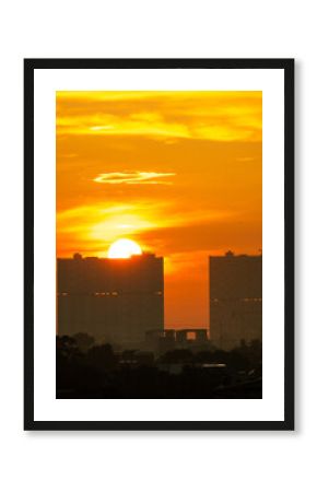 Golden sunset over city skyline creating a vibrant orange sky and dramatic silhouette