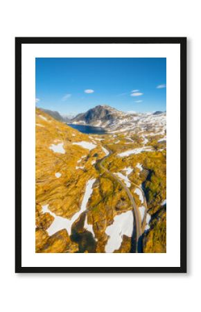 Nature in Norway. Drone view of wild Norway. Road among the rocks and mountains. Bright sunshine in the daytime. Vacation and travel in summer Norway. Background, wallpaper, postcards.