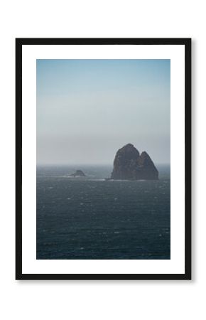 A pair of rocky islands sit steadfast in the Pacific Ocean in the Pacific Northwest, visible from Arch Rock State Park in Brookings, Oregon