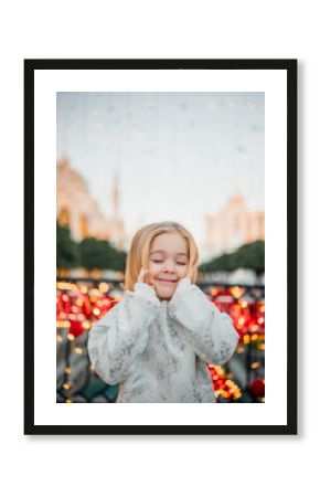 Joyful child enjoying festive lights at a holiday celebration in the city square