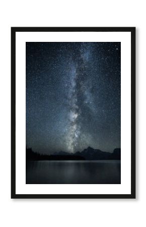 Milky Way stretching over Colter Bay Beach in Grand Teton National Park at night.