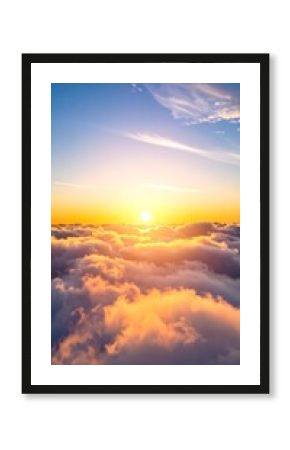 Aerial view of a radiant sunrise over a sea of fluffy clouds, transitioning into a bright blue sky