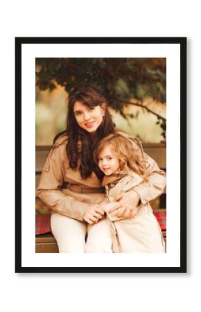 Mother and daughter enjoy a cozy moment in autumn park