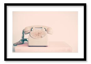 Vintage pink telephone over books