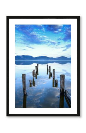 Wooden pier or jetty remains on a lake sunset. Tuscany, Italy