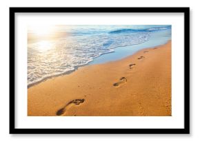 beach, wave and footprints at sunset time