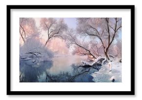 Сhristmas Lace.Winter landscape in pink tones with hoarfrost everywhere.Mostly calm winter river, surrounded by trees covered with hoarfrost and snow that falls on a beautiful pink morning light. 