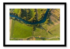 River bend surrounded by fields from bird's eye view.