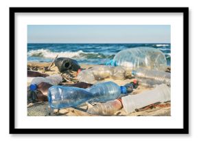 Spilled garbage on the beach of the big city. Empty used dirty plastic bottles. Dirty sea sandy shore the Black Sea. Environmental pollution. Ecological problem. Bokeh moving waves in the background  