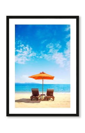 Two lounge chairs with sun umbrella on a beach