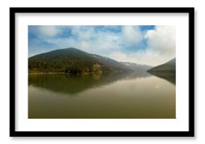Mountain range reflecting on river against sky