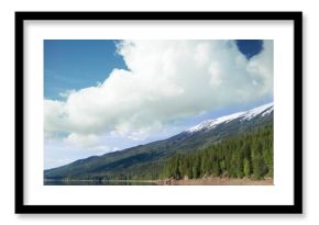 Scenic view of lake by trees and mountain against cloudy sky