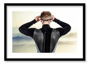 Rear view of male swimmer wearing swimming goggles at beach