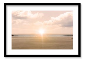 Bright sun disk is casting golden glow over sand, sea under cloud-speckled sky in flat design