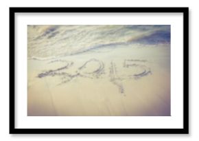 Year carved on sand by shore