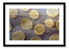 Scattering translucent lemon slices across rocky coastline, revealing foamy ocean waves
