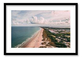 Drone shot of Cape Canaveral cityscape by the beach under cloudy sky in Florida