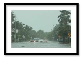 Flooded road with cars passing through during hurricane Nicole in Palm Beach, Florida. November 2022