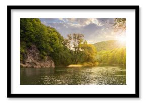 forest river with stones on shores at sunset