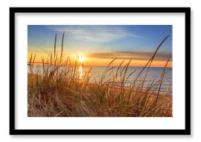 Dawn Of A New Day.Beautiful sunrise illuminates  sand dunes and the blue water horizon as a new day begins. Port Austin, Michigan.