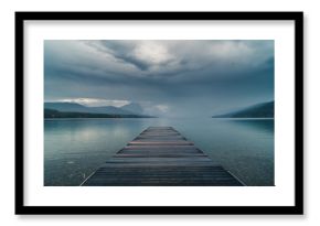 Dock overlooking a calm overcast lake.