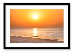 Sunset on the beach with long coastline, sun and dramatic sky 