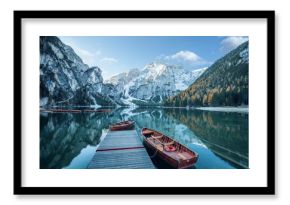 Klarer Gebirgssee mit Booten und Steg  vor felsiger Gebirgslandschaft 